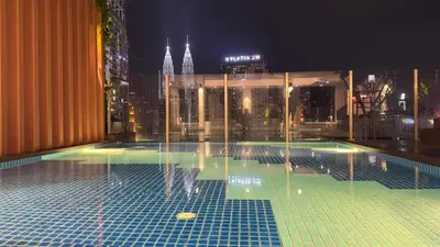 a pool on top of a building at night at Private family suite 27171BR at KLCC in Kuala Lumpur