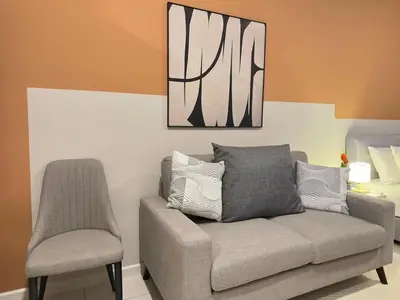 a living room with a couch and a chair at KLCC view cozy suite 251A at KLCC in Kuala Lumpur