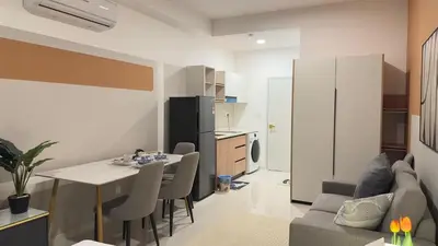 a kitchen and living room with a table and chairs at KLCC view cozy suite 251A at KLCC in Kuala Lumpur