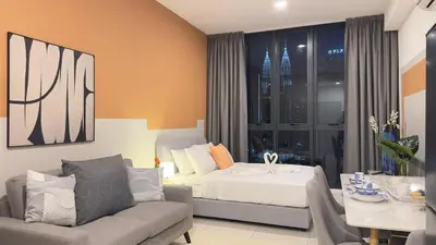 a bedroom with a bed and a couch and a table at KLCC view cozy suite 251A at KLCC in Kuala Lumpur