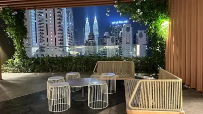 a table and chairs with a view of a city at KLCC view suite 292B at Majestic residence in Kuala Lumpur