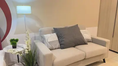 a living room with a couch and a table with a lamp at Luxe suite for couple 297B at Majestic Residence in Kuala Lumpur