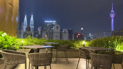 a patio with tables and chairs with a view of the city at Couple luxury suite 275B at Majestic Residence in Kuala Lumpur