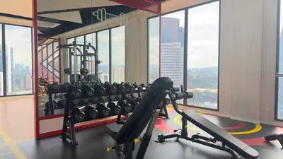 a gym with a bunch of machines and windows at KLCC view luxury suite 276B at Majestic residence in Kuala Lumpur