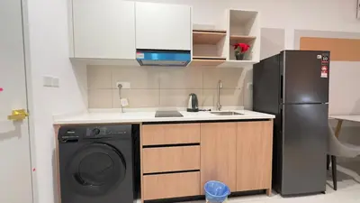a kitchen with a refrigerator and a washing machine at KLCC view luxury suite 276B at Majestic residence in Kuala Lumpur