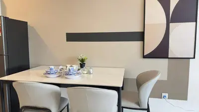 a dining room table with chairs and a table with cups and dishes on it at Private family suite 29201BR at Majestic Residence in Kuala Lumpur