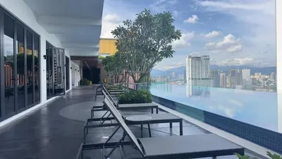 a swimming pool with tables and chairs on a building at Private family suite 29201BR at Majestic Residence in Kuala Lumpur