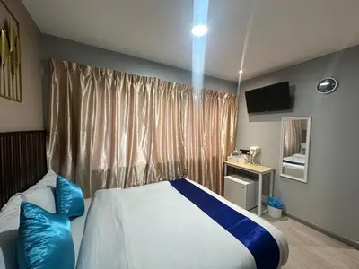 a bedroom with a bed with blue pillows and a window at SS GREY INN Bb in Kuala Lumpur