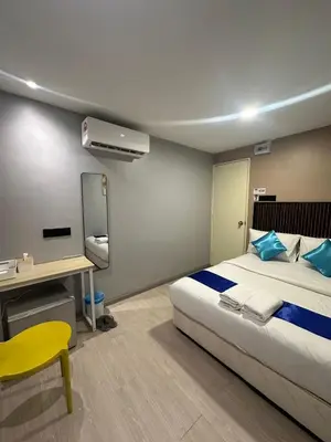 a bedroom with a bed and a desk with a yellow chair at SS GREY INN Bb in Kuala Lumpur