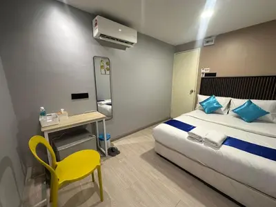 a hotel room with a bed and a yellow chair at SS GREY INN Bb in Kuala Lumpur