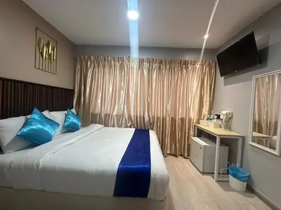 a bedroom with a bed with blue pillows and a window at SS GREY INN Bb in Kuala Lumpur