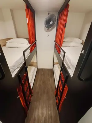 two bunk beds in a small room with a staircase at Traveller Ark Hotel and Bunks in Kuala Lumpur