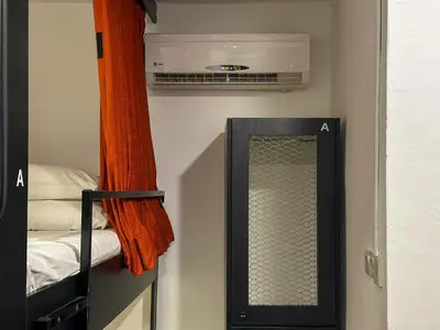 a bathroom with a mirror and a air conditioner at Traveller Ark Hotel and Bunks in Kuala Lumpur