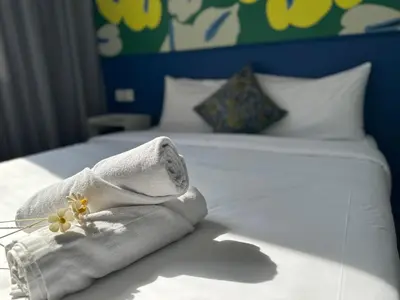 a towel with flowers on top of a bed at Traveller Ark Hotel and Bunks in Kuala Lumpur