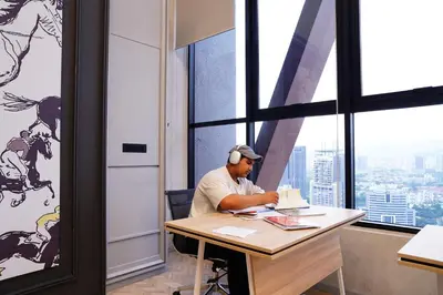 a man sitting at a desk in an office at Scarletz Suites By Home Stay in Kuala Lumpur