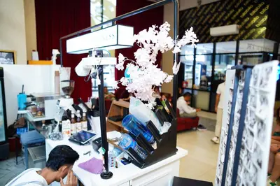 a man sitting at a counter in a store at Scarletz Suites By Home Stay in Kuala Lumpur