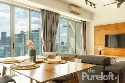a living room with a table and a large window at The Pureloft Suites - Bukit Bintang KLCC in Kuala Lumpur