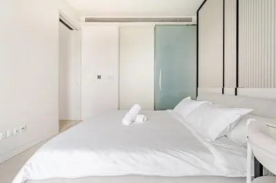 a bedroom with a large white bed with two towels on it at Romantic Home in KLCC in Kuala Lumpur