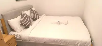 a white bed with a cross on top of it at Service Apartment Agile Residence KL in Kuala Lumpur