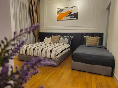 a bedroom with two beds and a ottoman at Cozy Velocity Residence2 Linked to Mall 6pax Wifi 600mbps in Kuala Lumpur