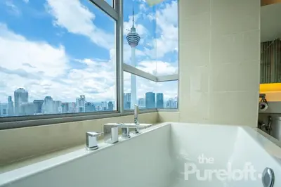 a bathroom with a bath tub with a large window at Suasana by TPL - Bukit Bintang KLCC in Kuala Lumpur