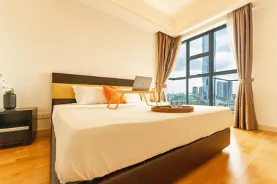 a bedroom with a bed with a laptop on it at Suasana by TPL - Bukit Bintang KLCC in Kuala Lumpur