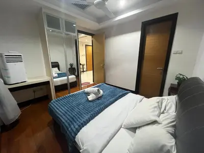 a bedroom with a bed with a blue blanket and a mirror at Casa Residency in Kuala Lumpur