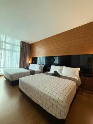 a hotel room with two beds and a large window at Family Suites KL Sentral in Kuala Lumpur