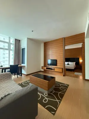 a living room with a bed and a television at Family Suites KL Sentral in Kuala Lumpur