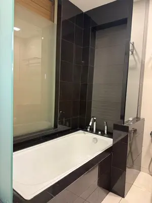 a bath tub with a large mirror in a bathroom at Family Suites KL Sentral in Kuala Lumpur