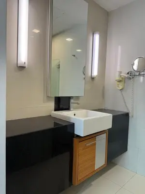 a bathroom with a white sink and a mirror at Family Suites KL Sentral in Kuala Lumpur