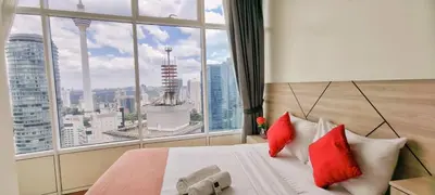 a bed with red pillows in a room with a window at Sky Suites KLCC by TD Luxe Global in Kuala Lumpur