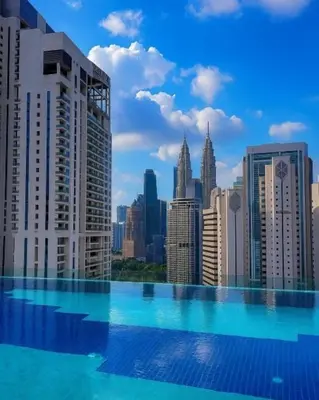 a large swimming pool with a view of a city at Majestic Residences KLCC By Moonlight in Kuala Lumpur