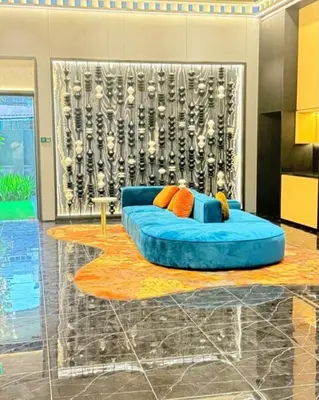 a living room with a blue couch in front of a wall at Majestic Residences KLCC By Moonlight in Kuala Lumpur