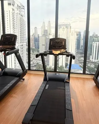 a gym with two treadmills in front of a large window at Majestic Residences KLCC By Moonlight in Kuala Lumpur