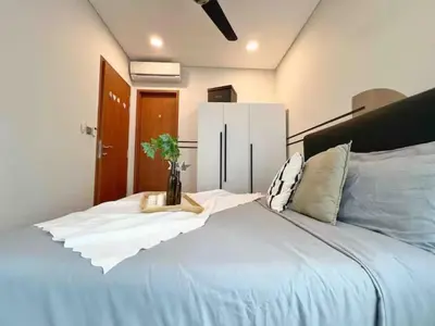 a bedroom with a large white bed with a plant on it at Nook Sky Suites KLCC in Kuala Lumpur