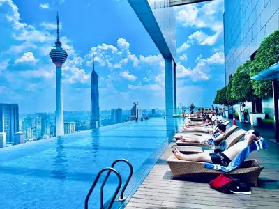 a group of people laying on the edge of a swimming pool at Platinum Suites Kuala Lumpur Malaysia By LuzBnB in Kuala Lumpur