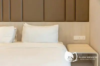 a bed with white sheets and pillows in a room at Societe Suites Hartamas by Plush in Kuala Lumpur