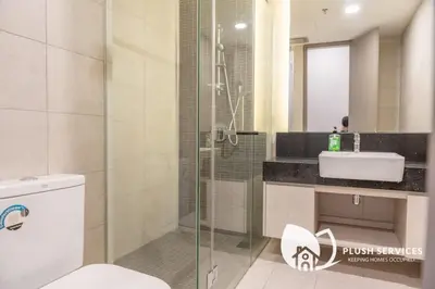 a bathroom with a shower and a toilet and a sink at Societe Suites Hartamas by Plush in Kuala Lumpur