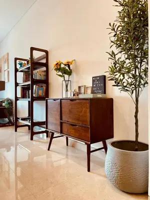 a wooden dresser and a potted tree in a room at Lucentia Residences By ONZO in Kuala Lumpur