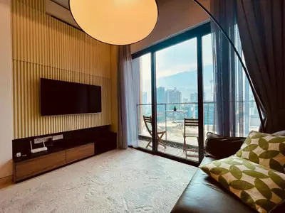a living room with a television and a large window at Lucentia Residences By ONZO in Kuala Lumpur