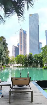 a bench in front of a pond in a city at Service Residence Agile Delima Residence KL in Kuala Lumpur
