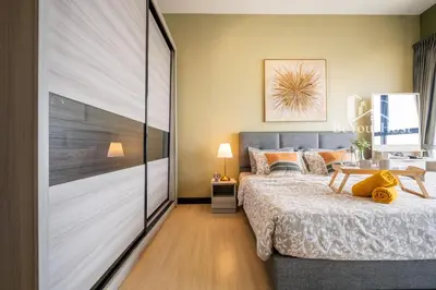a bedroom with a large bed and a table at Continew Residences Kuala Lumpur in Kuala Lumpur