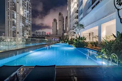 a large swimming pool in a city at night at Quill Residence KLCC By UrbanNest in Kuala Lumpur