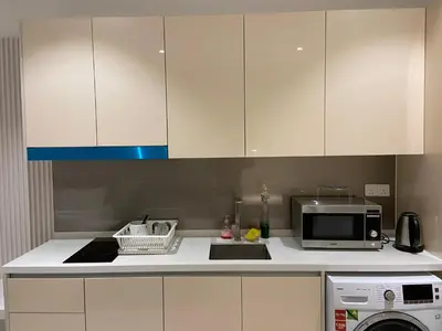 a kitchen with white cabinets and a sink and a microwave at Quill Residence KLCC By UrbanNest in Kuala Lumpur