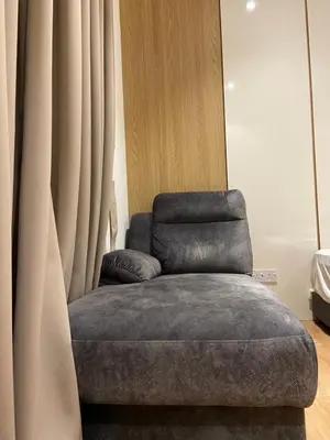a gray ottoman sitting next to a curtain at Quill Residence KLCC By UrbanNest in Kuala Lumpur