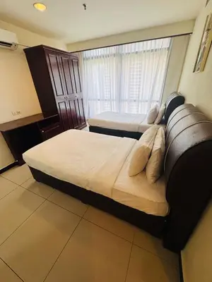 a bedroom with two beds and a couch at Times Square KL Serviced Suite in Kuala Lumpur