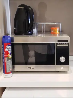 a microwave sitting on a shelf with a coffee pot at Quill Residence KLCC Suites City Home in Kuala Lumpur