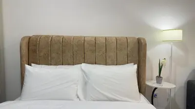 a bed with a large headboard and white pillows at KLCC view suite 1601B at Majestic Residence in Kuala Lumpur