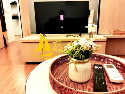 a table with a vase of flowers and a remote control at Swiss Garden Residence by The Layar Homes in Kuala Lumpur